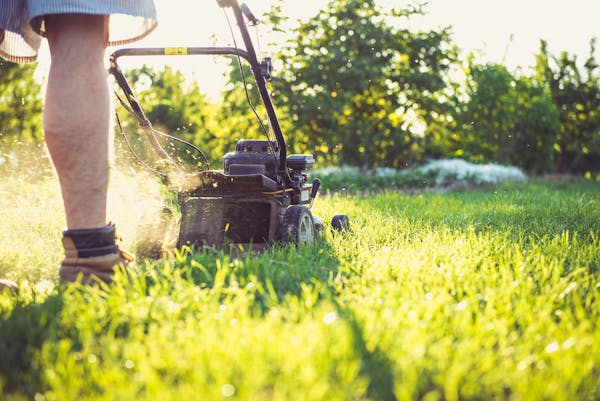 Landscaper mowing lawn
